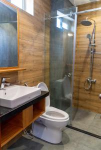 a bathroom with a toilet and a glass shower at Coast House Boutique Hotel in Nha Trang