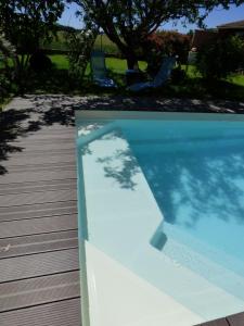 a picture of a swimming pool with a tree shadow at Arche de Lanoë jacuzzi in Labastide-Saint-Pierre