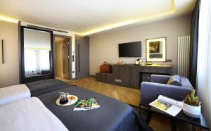 uma sala de estar com um sofá e uma televisão em The Capital Hotel em Istambul