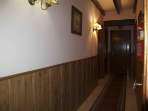 a hallway with wood paneled walls and a door at Posada el Tocinero in Camargo
