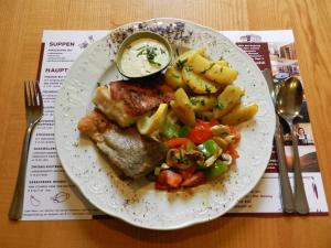 ein Teller mit Fleisch und Kartoffeln auf dem Tisch in der Unterkunft Freinerhof & Wellness in Neuberg an der Mürz