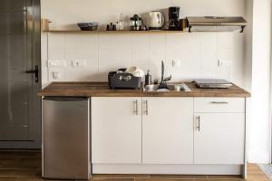 een keuken met witte kasten en een wastafel bij Laura maisons in Kalamata