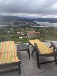 two benches sitting on top of a balcony at Nores Buenavista 2 in Vilaboa
