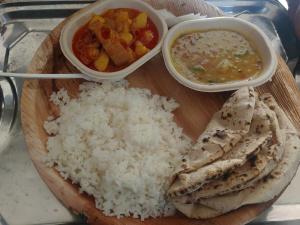 um prato de arroz e legumes e uma tigela de sopa em City Hotel em Allahabad