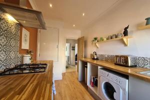 a kitchen with a stove and a washer and dryer at Central St Leonards on sea Apartment in Hastings