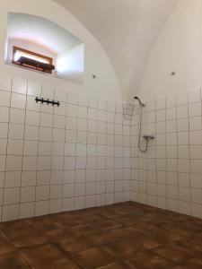 y baño con ducha de azulejos blancos. en Penzion a hospoda Na statku, en Hluboká nad Vltavou