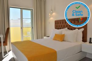 
a white bed with a blue and white bedspread at Hotel Sol Algarve by Kavia in Faro
