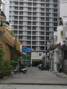 un aparcamiento con motocicletas estacionado frente a un gran edificio en Hill Inn, en Pattaya South