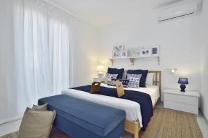 a bedroom with a large bed with blue and white pillows at CASA BLANCA A 2 PASSI DEL MARE Santa Maria del Focallo in Santa Maria Del Focallo