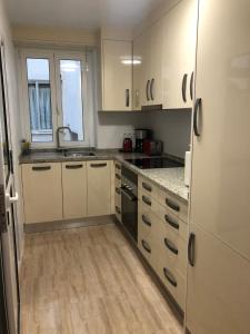a kitchen with white cabinets and a wooden floor at Torrevieja - LaMata - Sonny in La Mata