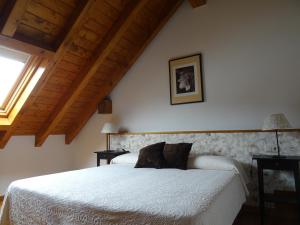 a bedroom with a white bed and a window at Hotel Rural Aribe Irati in Aribe