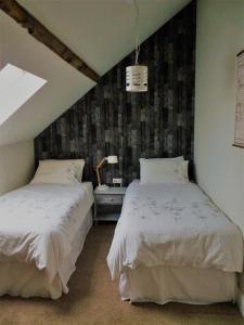 - une chambre avec 2 lits et un plafond avec une fenêtre dans l'établissement Een prachtige Gîte in Frankrijk Chez Gerard, à Vieilleville