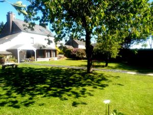 einen Hof mit einem Baum und einem Haus in der Unterkunft vive les vacances in Plouguenast Langast