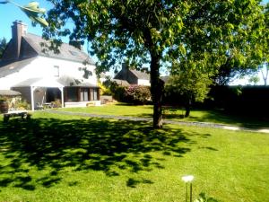 un patio con un árbol y una casa en vive les vacances, en Gausson