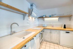 eine Küche mit weißen Schränken und einem Waschbecken in der Unterkunft Première ligne - Première conciergerie in Palavas-les-Flots