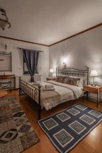 a bedroom with a large bed and a blue rug at Beloi Hotel in Vitsa