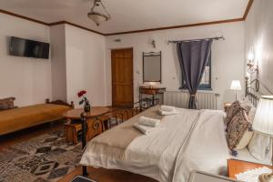 1 dormitorio con 1 cama grande y 1 sofá en Beloi Hotel, en Vitsa