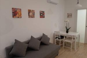 salon z kanapą i stołem w obiekcie Casetta ALU' - il tuo nido a Stampace w Cagliari