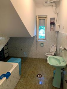 a bathroom with a sink and a toilet and a tub at Hostel Holiday Cetinje in Cetinje