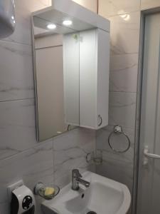 a bathroom with a white sink and a mirror at Apartman Azzuro Vrnjačka Banja in Vrnjačka Banja