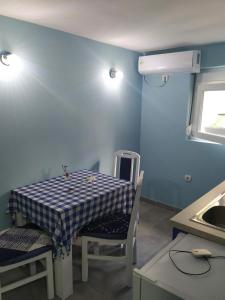 a table and chairs in a kitchen with a blue wall at Apartman Azzuro Vrnjačka Banja in Vrnjačka Banja