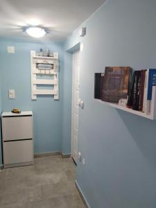 a room with a blue wall with a door and a shelf at Apartman Azzuro Vrnjačka Banja in Vrnjačka Banja