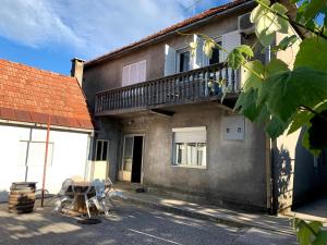 a house with a balcony and a table and chairs at Hostel Holiday Cetinje in Cetinje