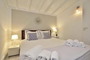 una camera da letto con un grande letto bianco con asciugamani di Romantic House Porto Ulisse a Santa Maria del Focallo