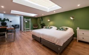 a bedroom with a large bed and a dining room at Familie Hotel & Apartments Alkmaar in Alkmaar