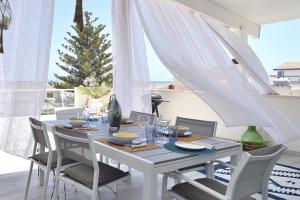 a white table with chairs and a table and a christmas tree at MARZAMEMI TERRAZZA VISTA MARE in Marzamemi