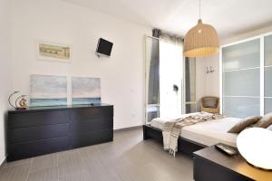 a bedroom with a bed and a dresser and a tv at MARZAMEMI TERRAZZA VISTA MARE in Marzamemi