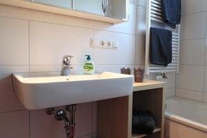 a bathroom sink with a bottle of soap on it at Ferienwohnungen Fricker in Oberstdorf +24 photos