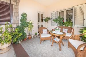 a patio with wicker chairs and a table with plants at S&P City Center Apartments in Kotor