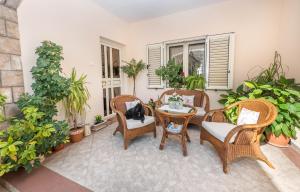 a patio with wicker chairs and tables and plants at S&P City Center Apartments in Kotor