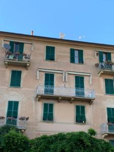 ラパッロにあるHoliday in Portofino by PortofinoVacanzeの緑の窓とバルコニーが備わる建物