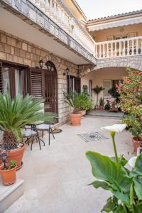 an outdoor patio with plants and tables and chairs at S&P City Center Apartments in Kotor