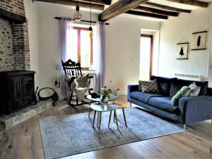 a living room with a blue couch and a fireplace at Een prachtige Gîte in Frankrijk Chez Gerard in Vieilleville