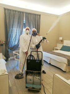 two people in a hotel room with a vacuum cleaner at B&B La Residenza Dell'Orafo in Florence