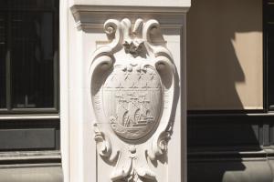 a white building with a crest on the side of it at Hôtel Gramont in Paris