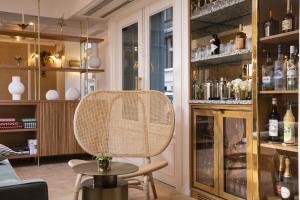 a room with a rattan chair and a table at Hôtel Gramont in Paris