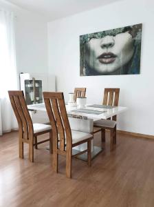 a dining room with a table with chairs and a painting at Petro delux apartments center in Kaunas
