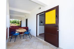 a door leading to a patio with a table and chairs at Apartment Plemić in Pag