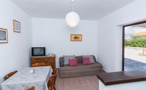 a living room with a table and a couch at Apartment Plemić in Pag