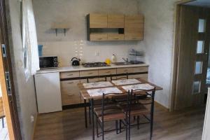 a small kitchen with a table and a stove at Domki u Piotrusia in Żarnowska