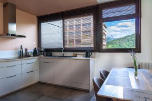 a kitchen with white cabinets and a table and a window at Mountain Suite in Annecy