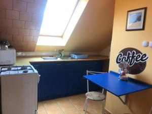 kuchnia z niebieskimi szafkami i niebieskim stołem w obiekcie Apartman Sas 6 w Hajduszoboszlo