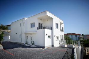 un condominio bianco con vialetto di Apartmani Kelava a Trogir