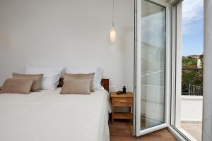 ein Schlafzimmer mit einem weißen Bett und einem Fenster in der Unterkunft Apartmani Kelava in Trogir