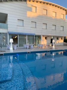 a hotel with a swimming pool in front of a building at Elite Boutique Hotel in Roseto degli Abruzzi