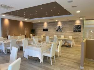 阿布鲁齐的罗塞托Elite Boutique Hotel的用餐室配有白色的桌子和白色的椅子